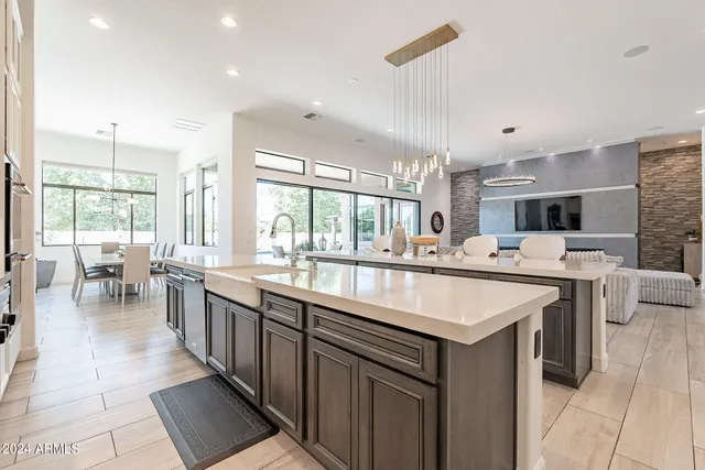 a large kitchen with kitchen island a sink table and chairs