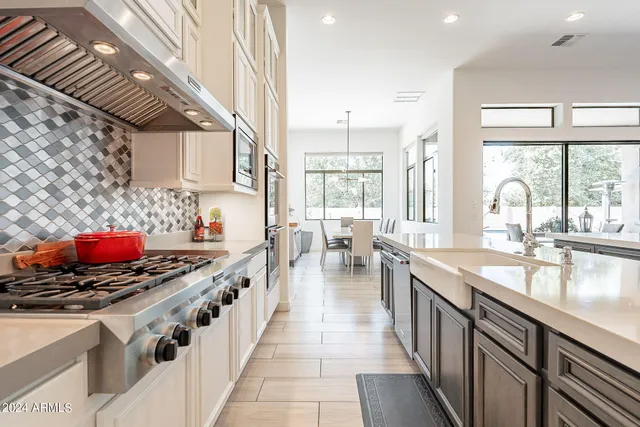 a kitchen with stainless steel appliances a sink stove and cabinets