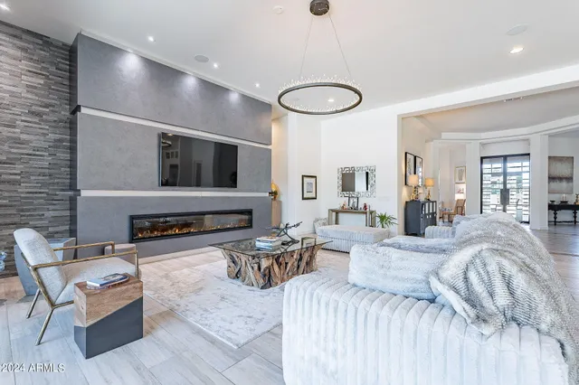 a bedroom with furniture a flat screen tv and a fireplace