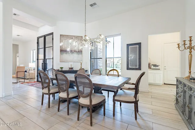 a view of a dining room and livingroom with furniture wooden floor a chandelier