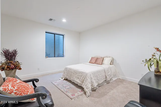 a bedroom with a bed and a potted plant