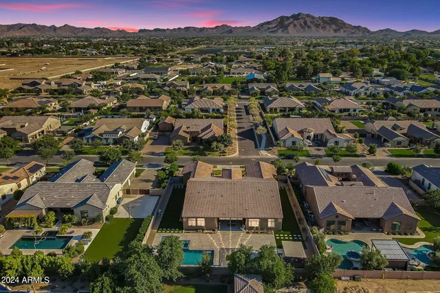 an aerial view of a city with lots of residential buildings and mountain view in back