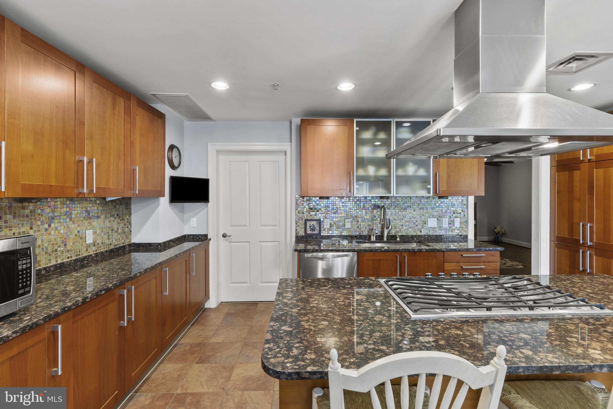 801 Key Highway, Unit 251 Baltimore, MD 21230 - Photo 11 of 57 a large kitchen with kitchen island granite countertop wooden cabinets and a granite counter tops