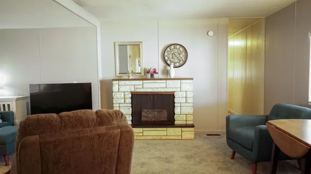 a living room with furniture a mirror and a fireplace