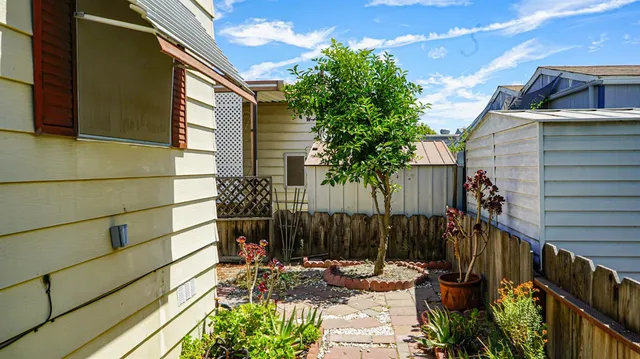 a view of a patio with table and chairs and potted plants with wooden fence