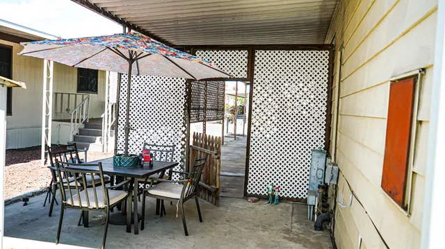 a backyard of a house with table and chairs