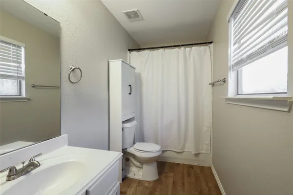 a bathroom with a toilet a sink and a window