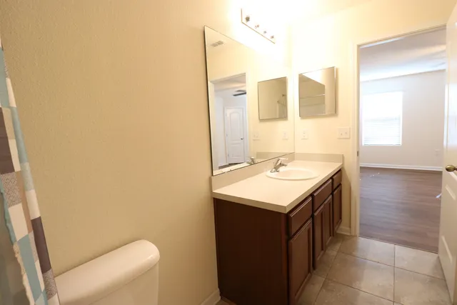 a view of a room with wooden floor and a ceiling fan