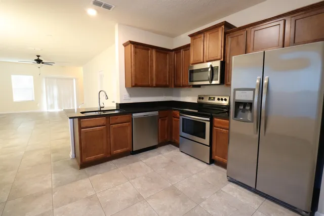 a kitchen with stainless steel appliances granite countertop a refrigerator sink and cabinets