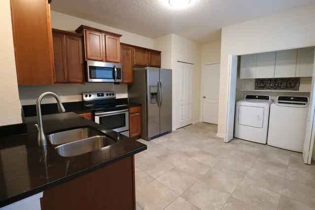 a kitchen that has a sink cabinets and stainless steel appliances