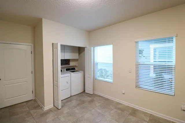 an empty room with windows and a ceiling fan
