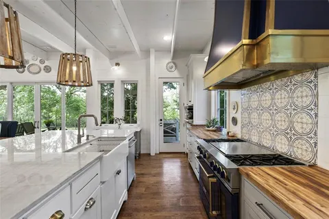 a kitchen with stainless steel appliances granite countertop a stove a sink and a refrigerator