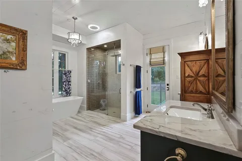 a bathroom with a granite countertop sink a mirror and shower