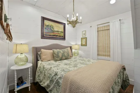 a bedroom with a bed and a chandelier