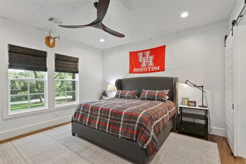 a bedroom with a bed a dresser next to a window