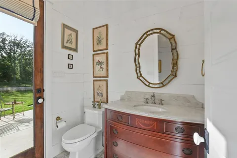 a bathroom with a toilet a sink and a mirror