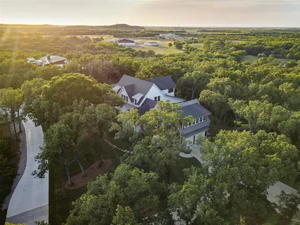 an aerial view of residential houses with outdoor space and trees