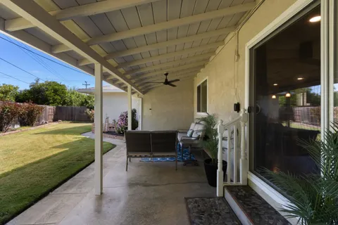 a view of a porch with chairs and potted plants