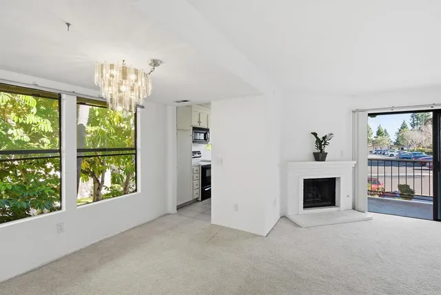 an empty room with windows and fireplace