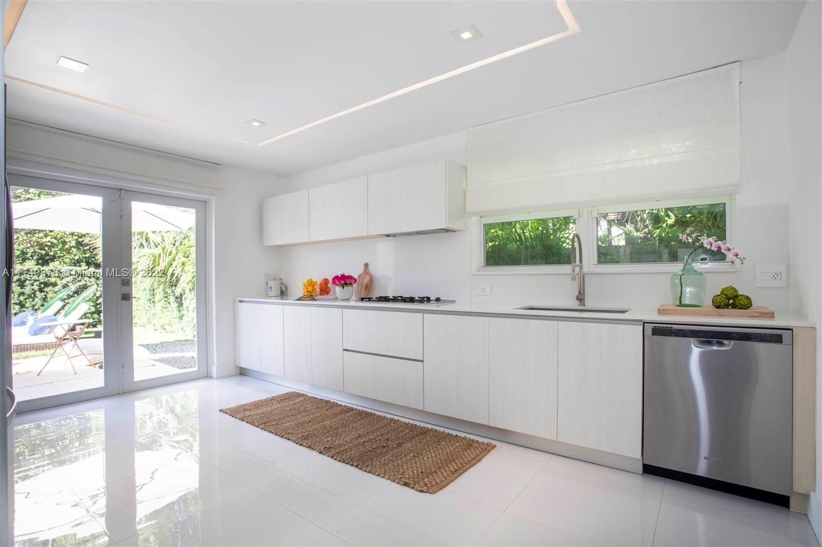 3020 Alton Road Miami Beach, FL 33140 - Photo 15 of 22 a kitchen with a sink window and cabinets