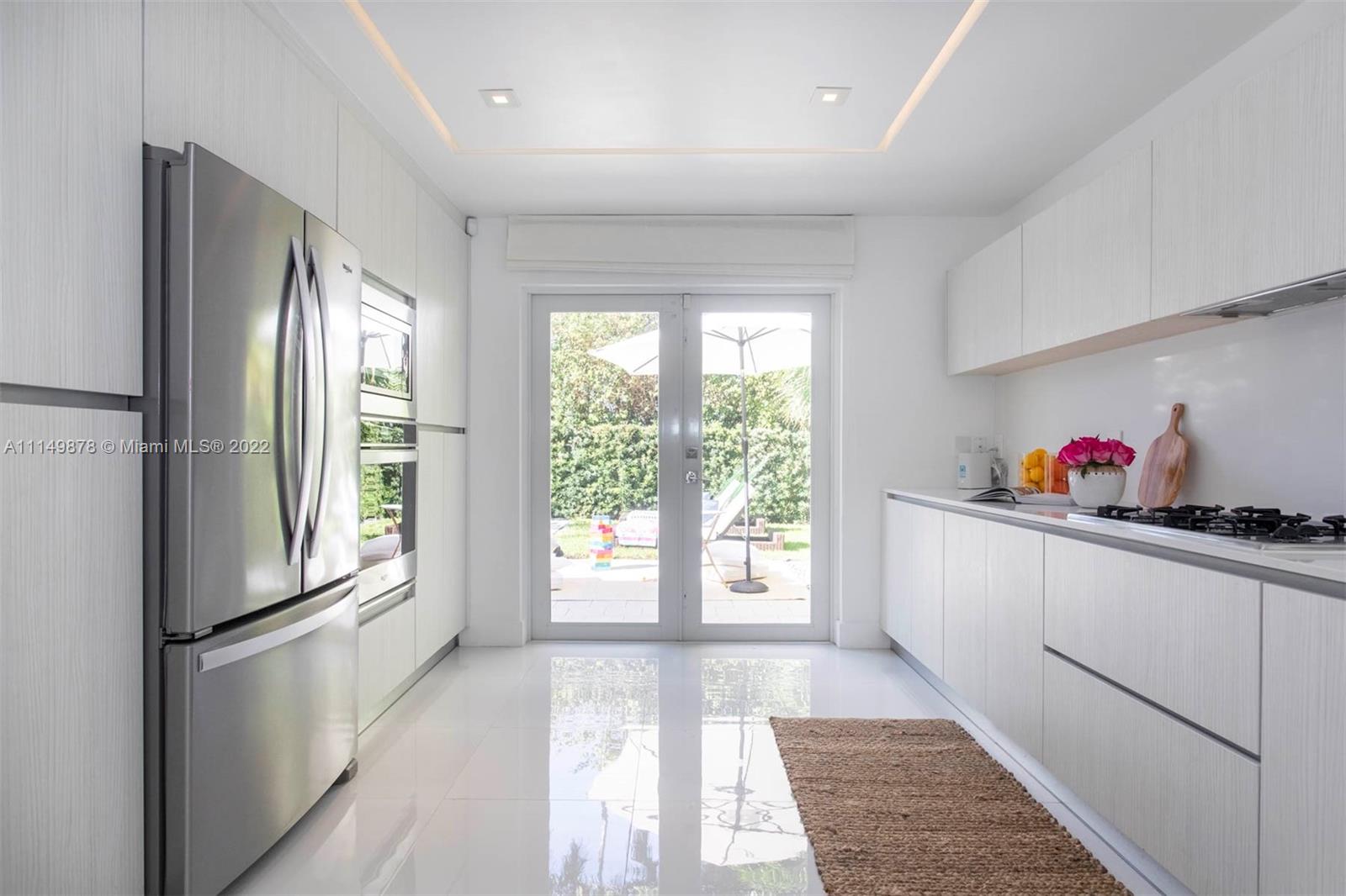 3020 Alton Road Miami Beach, FL 33140 - Photo 16 of 22 a kitchen with granite countertop a refrigerator and a sink