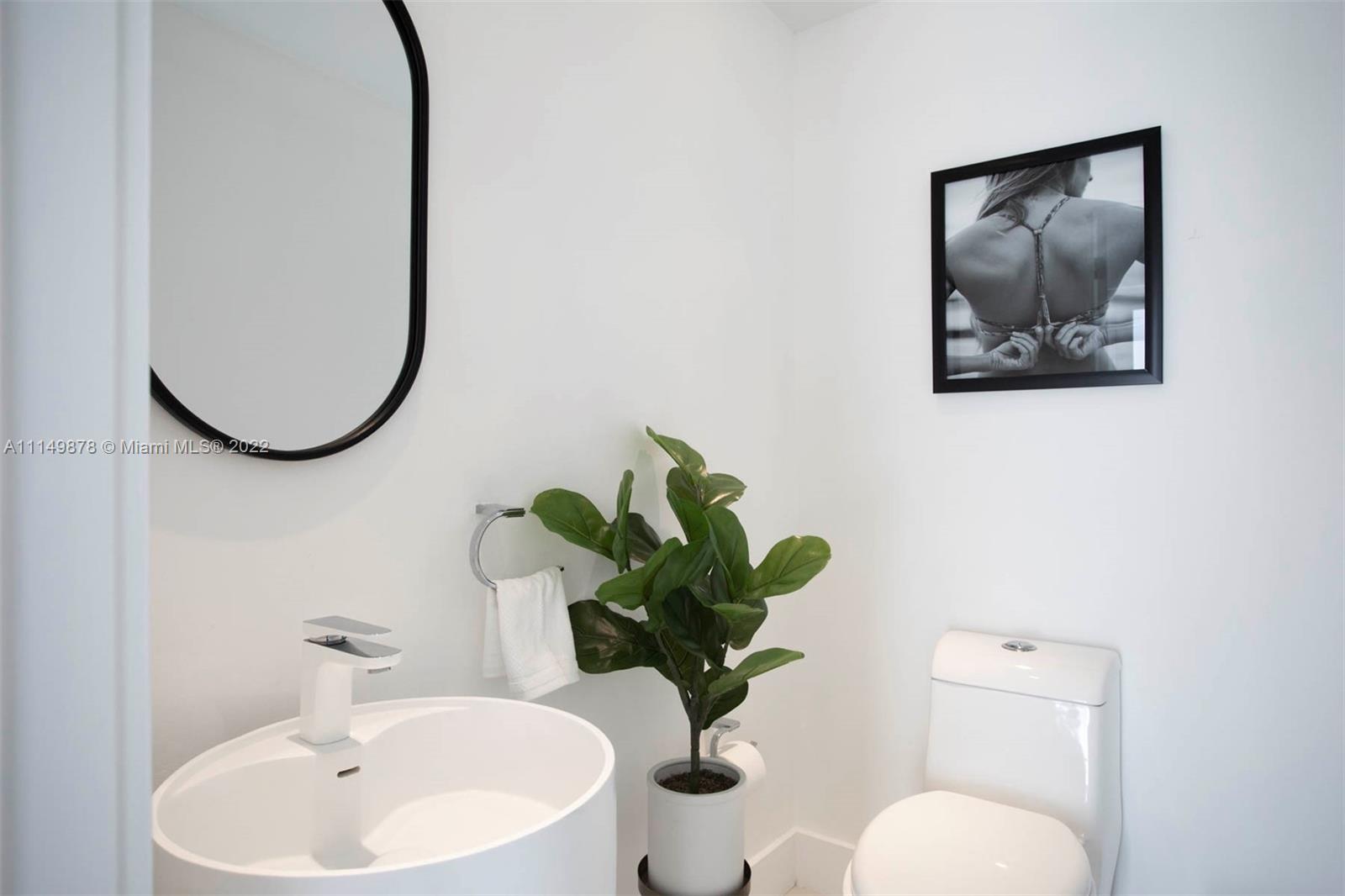 3020 Alton Road Miami Beach, FL 33140 - Photo 20 of 22 a bathroom with a toilet sink and mirror