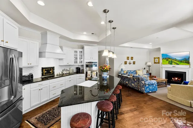 a kitchen with stainless steel appliances granite countertop a stove refrigerator and cabinets