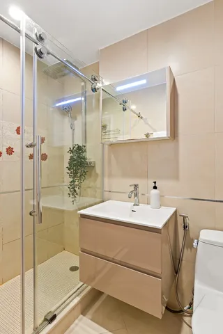 a bathroom with a sink mirror and a shower