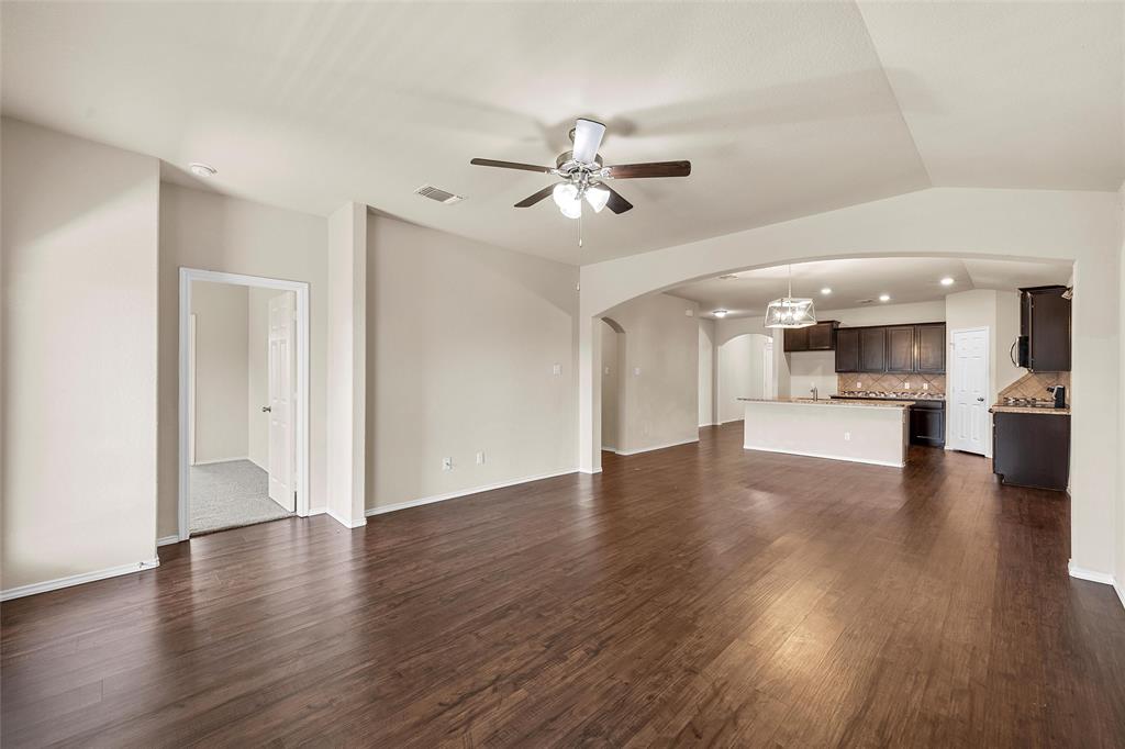 3217 Beutel Road Lorena, TX 76655 - Photo 17 of 40 Unfurnished living room with arched walkways, ceiling fan, and dark wood-style floors