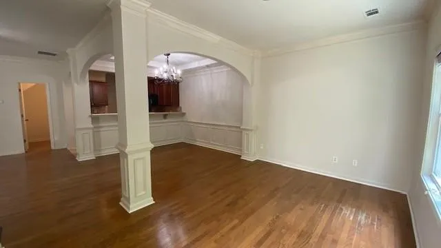 an empty room with wooden floor fireplace and windows