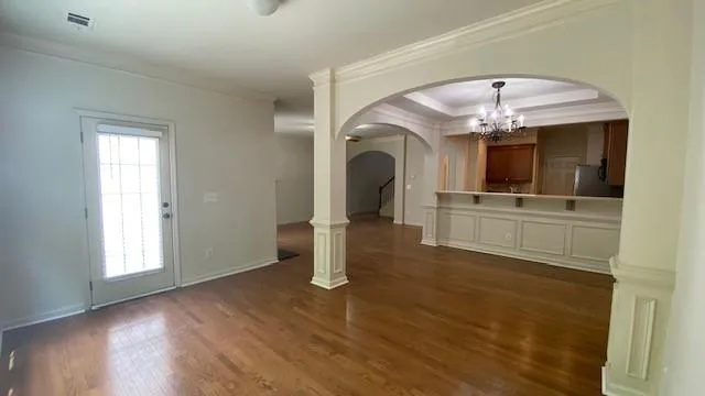 an empty room with wooden floor fireplace and windows