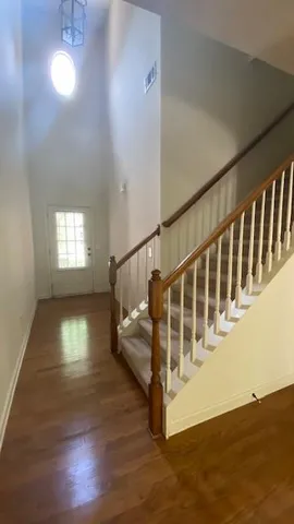 a view of a hallway with wooden floor and staircase