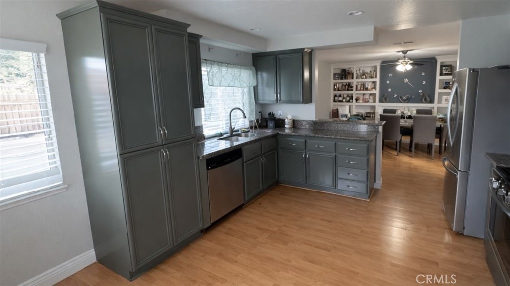 19972 Windwood Circle Riverside, CA 92508 - Photo 4 of 11 a kitchen with stainless steel appliances granite countertop a refrigerator a sink dishwasher a stove with wooden cabinets and floors