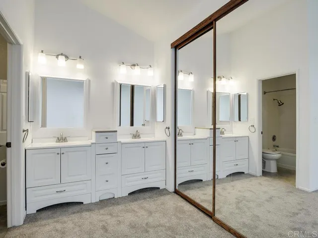 a bathroom with a double vanity sink mirror and toilet