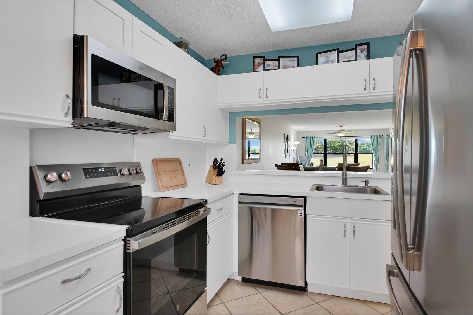 4708 Lucerne Lakes Boulevard East, Unit 104 Lake Worth, FL 33467 - Photo 11 of 28 a kitchen with white cabinets and stainless steel appliances