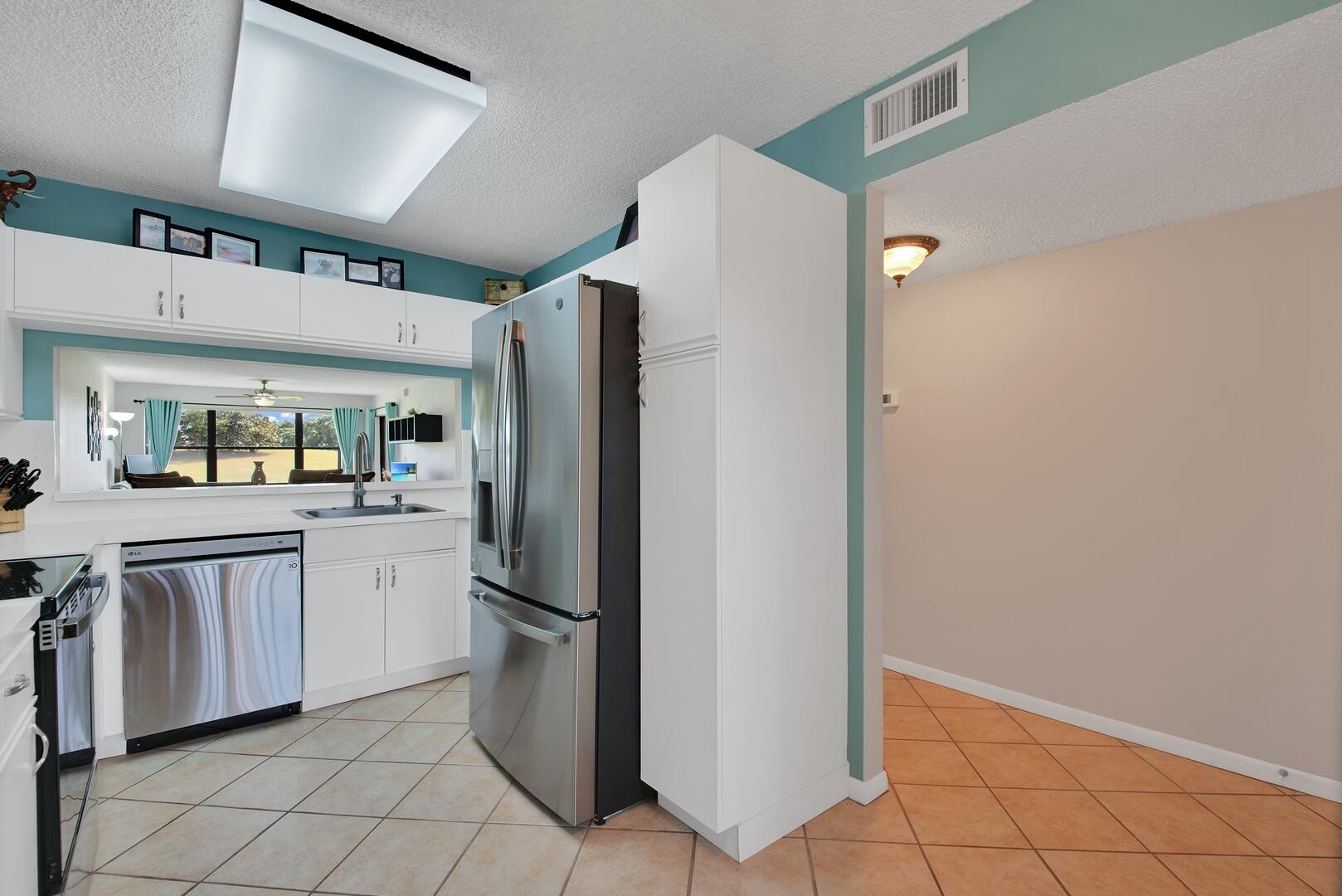 4708 Lucerne Lakes Boulevard East, Unit 104 Lake Worth, FL 33467 - Photo 13 of 28 a kitchen with white cabinets and refrigerator