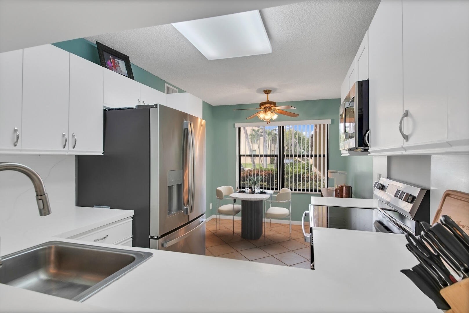 4708 Lucerne Lakes Boulevard East, Unit 104 Lake Worth, FL 33467 - Photo 14 of 28 a kitchen with a refrigerator and a sink