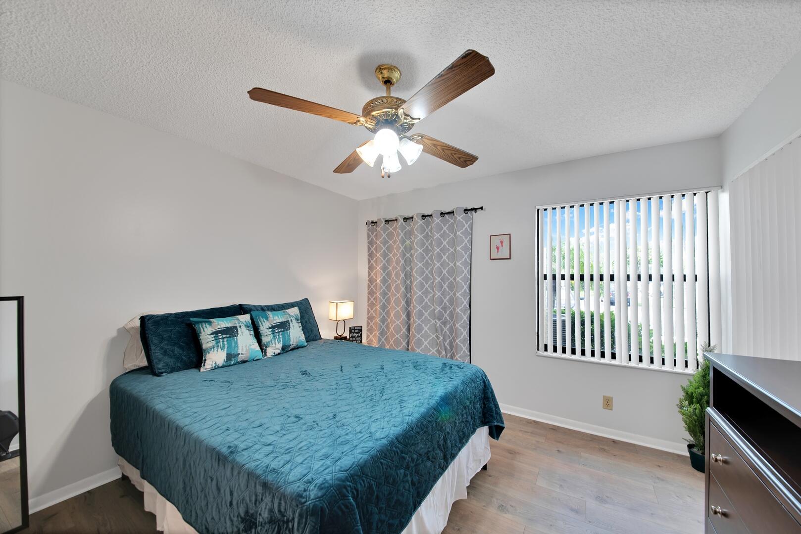 4708 Lucerne Lakes Boulevard East, Unit 104 Lake Worth, FL 33467 - Photo 18 of 28 a bedroom with a bed and a chandelier