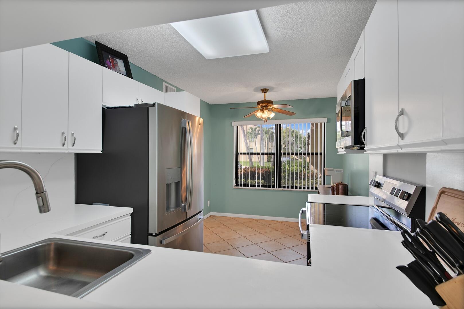 4708 Lucerne Lakes Boulevard East, Unit 104 Lake Worth, FL 33467 - Photo 19 of 28 a kitchen with a refrigerator and a sink