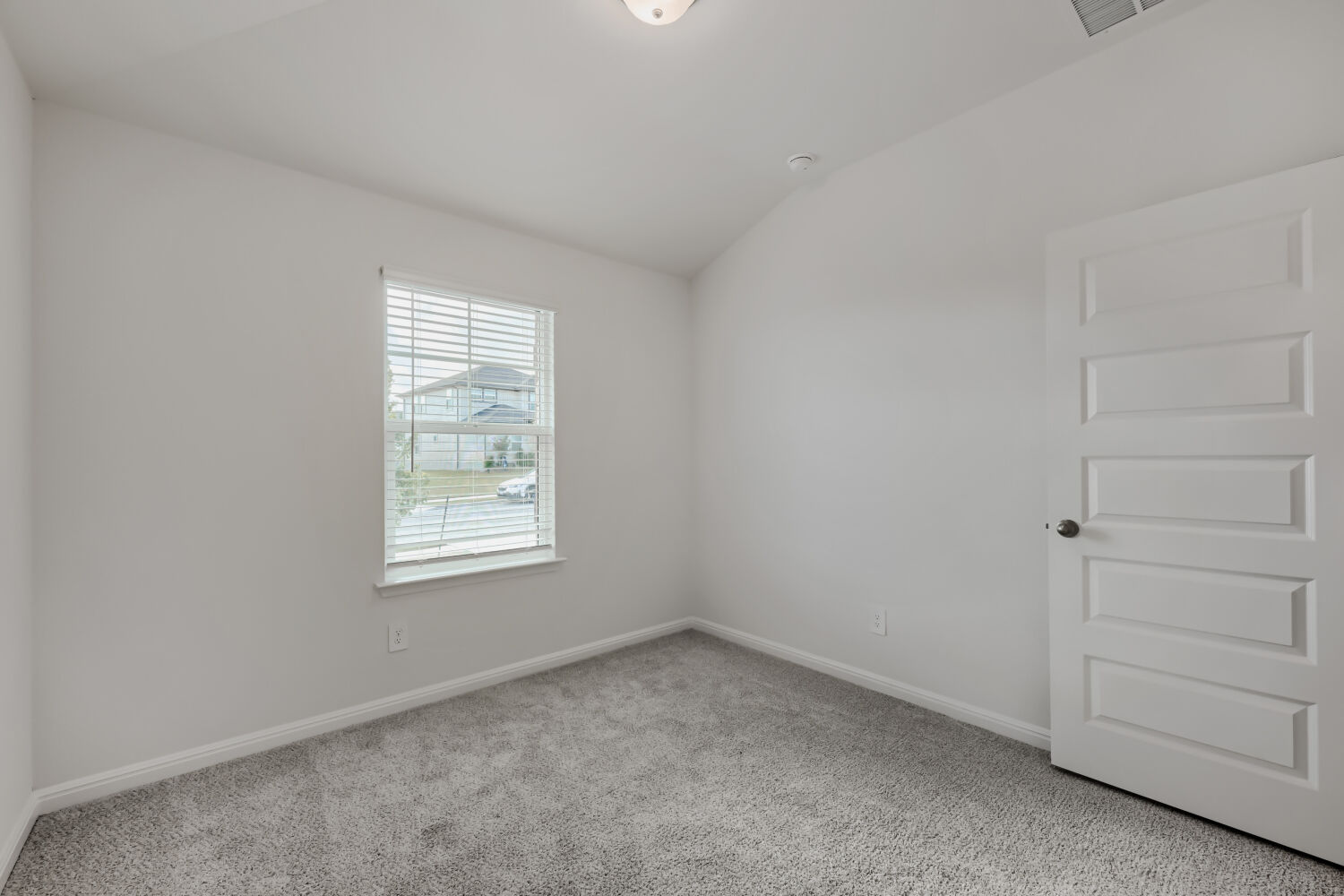 146 Diablo Rim Terrace Dripping Springs, TX 78620 - Photo 20 of 32 A well-lit bedroom features plush carpeting and a window overlooking the neighborhood.