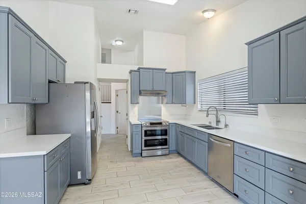 a kitchen with stainless steel appliances a refrigerator sink and cabinets