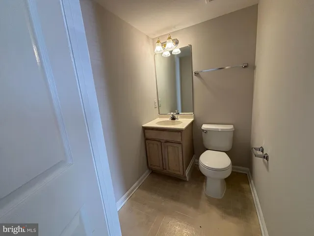 a white toilet sitting next to a bathroom sink and a mirror