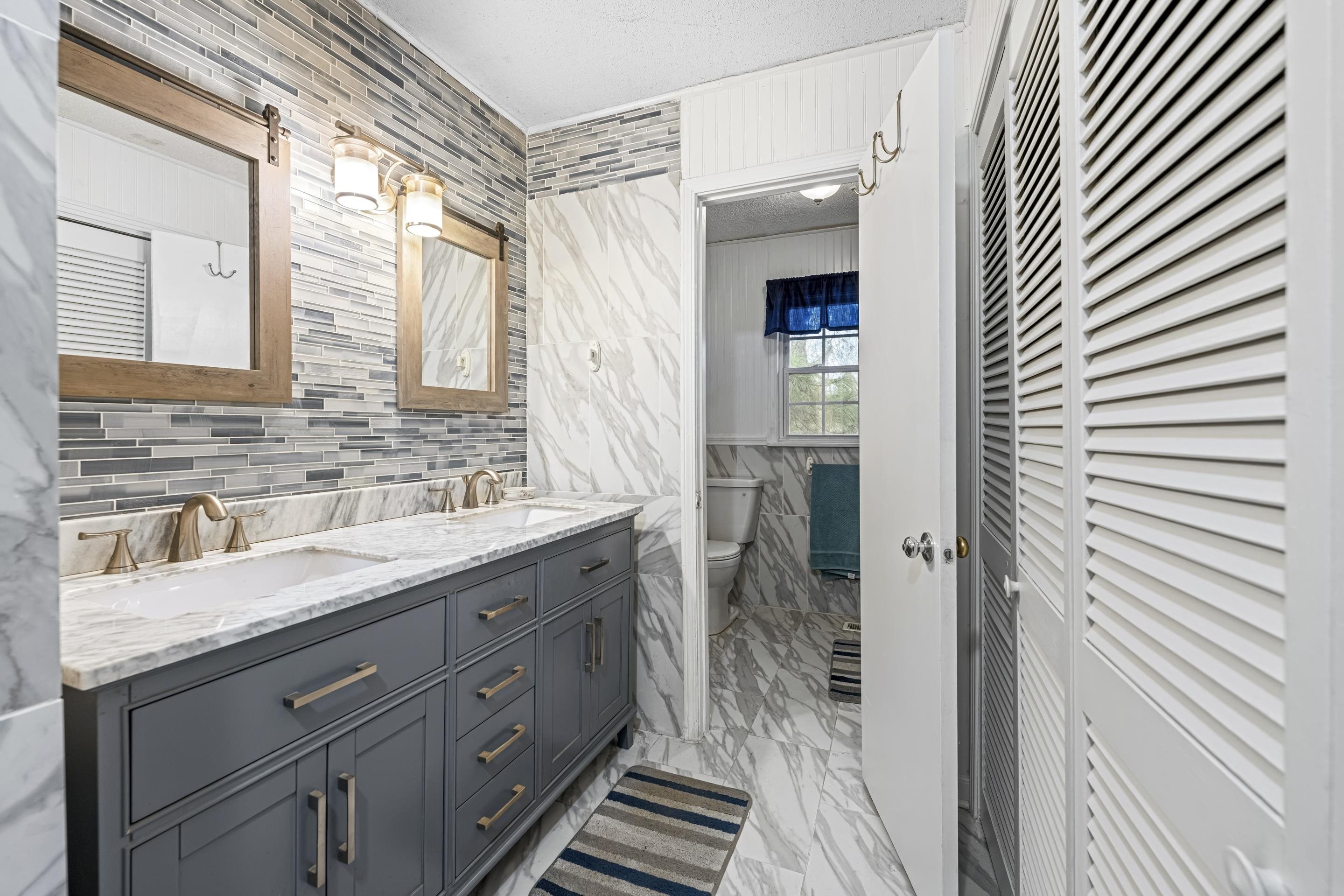 754 McWilliams Road Covington, TN 38019 - Photo 14 of 28 a bathroom with a granite countertop sink a mirror and shower