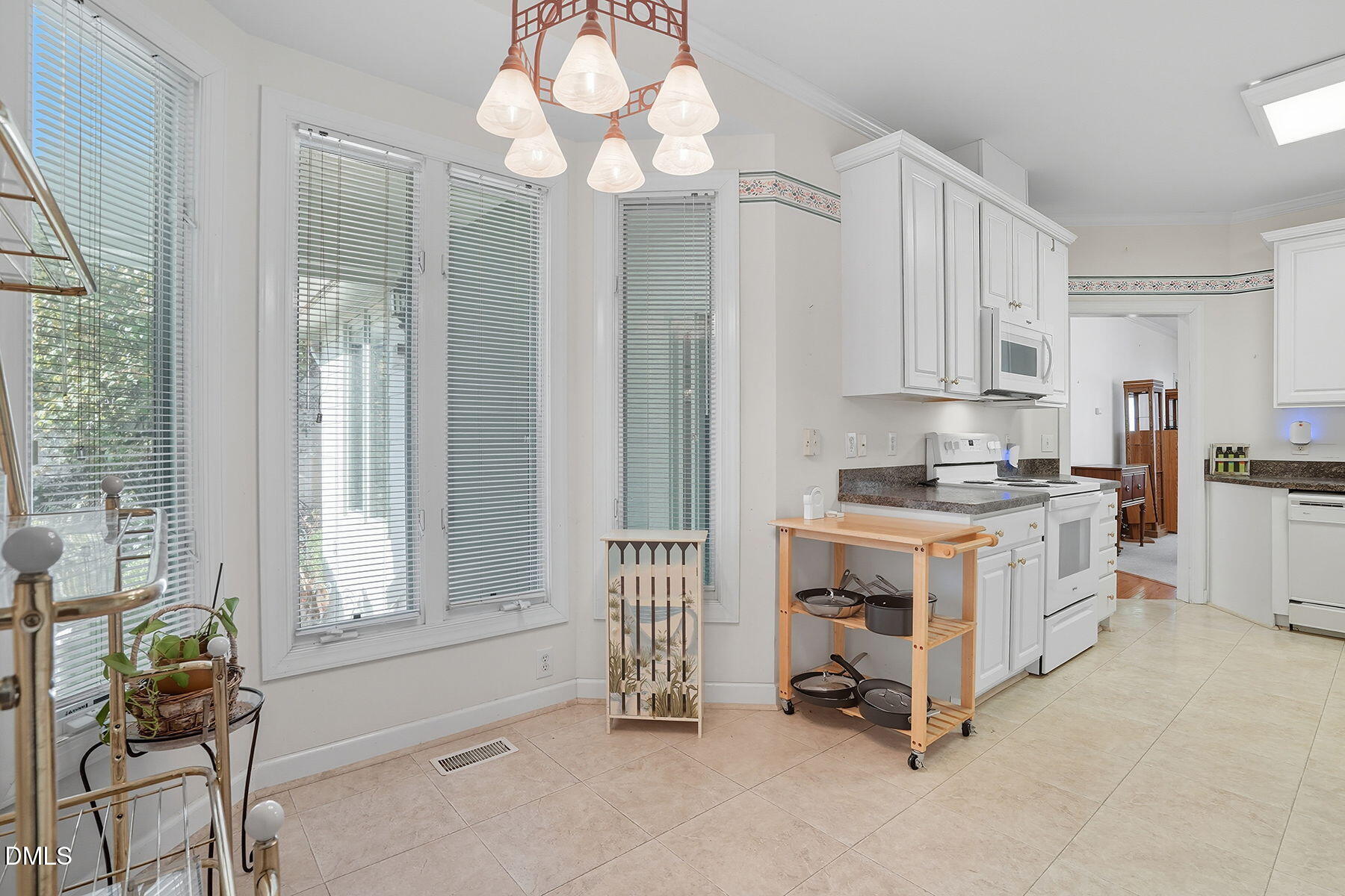 2029 Castle Pines Drive Raleigh, NC 27604 - Photo 18 of 38 a kitchen that has a lot of white cabinets and wooden floor