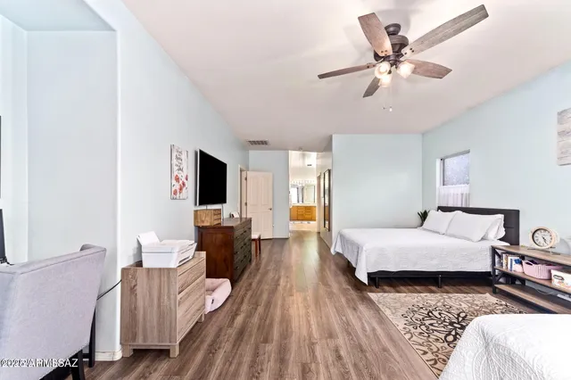 a spacious bedroom with a bed and wooden floor