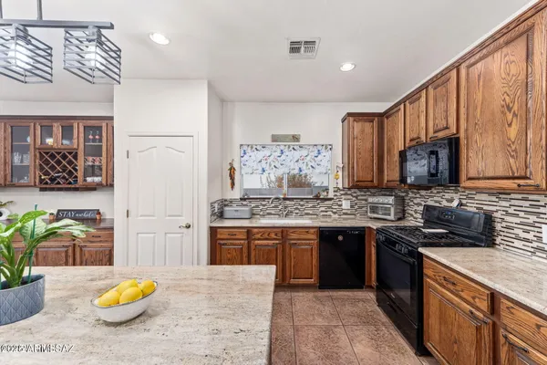 a kitchen with stainless steel appliances granite countertop a stove a sink dishwasher and cabinets with wooden floor