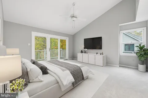 a spacious bedroom with a bed and a flat screen tv