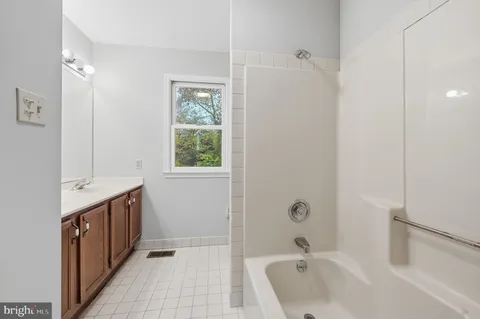 a bathroom with a tub sink and mirror