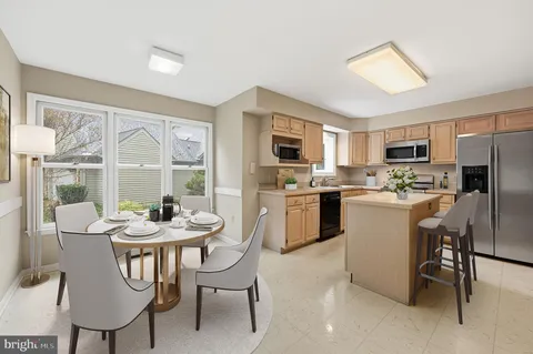 a kitchen with sink a refrigerator and chairs