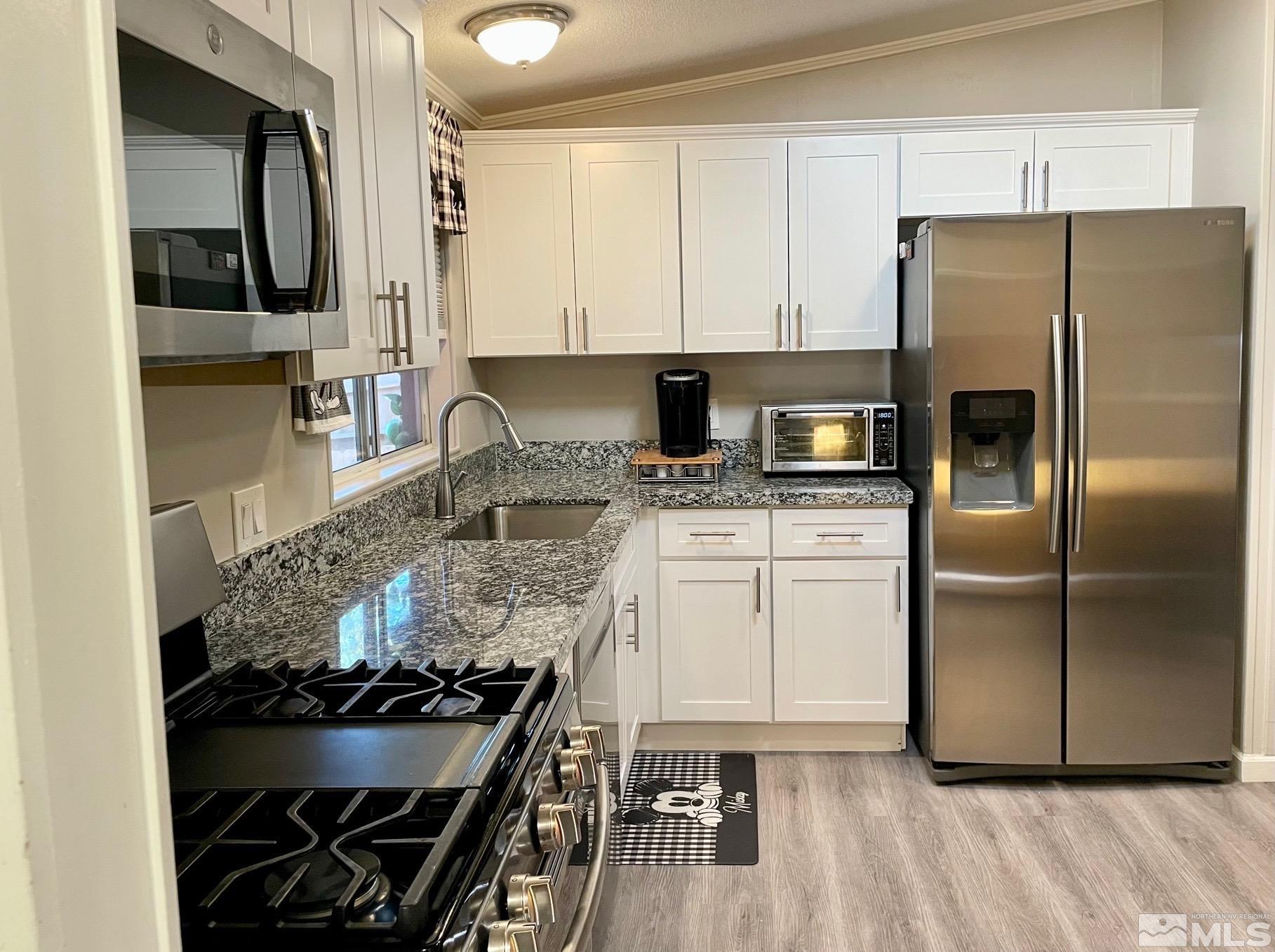 2197 Barberry Way Reno, NV 89512 - Photo 3 of 18 a kitchen with a stove a refrigerator and cabinets